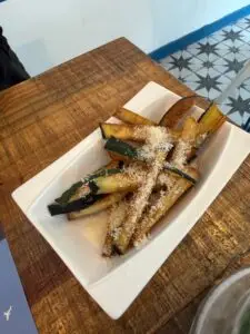 Tiras de calabacín y berenjena fritas con queso parmesano, aperitivo de cortesía de Capri Blu.