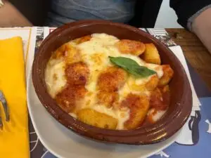 Gnocchi alla Sorrentina gratinados con mozzarella y tomate en cazuela de barro en Capri Blu.